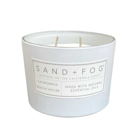 Sand + Fog California Beach House candle glass vessel enhances decor with warm coastal glow.