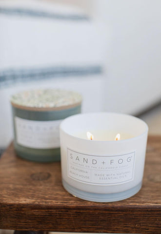 Sand + Fog candle glows softly, creating inviting ambience.