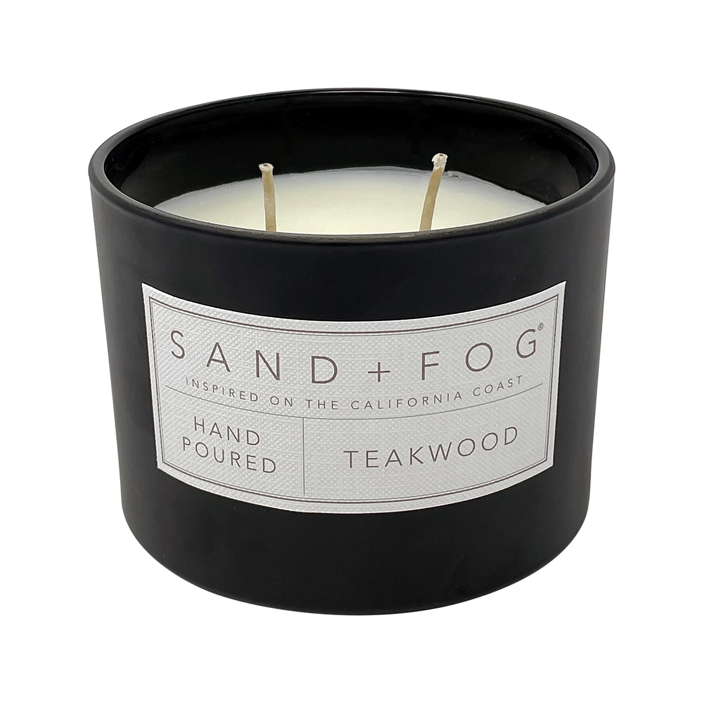 Sand + Fog teakwood candle on a table beside its decorative lid.