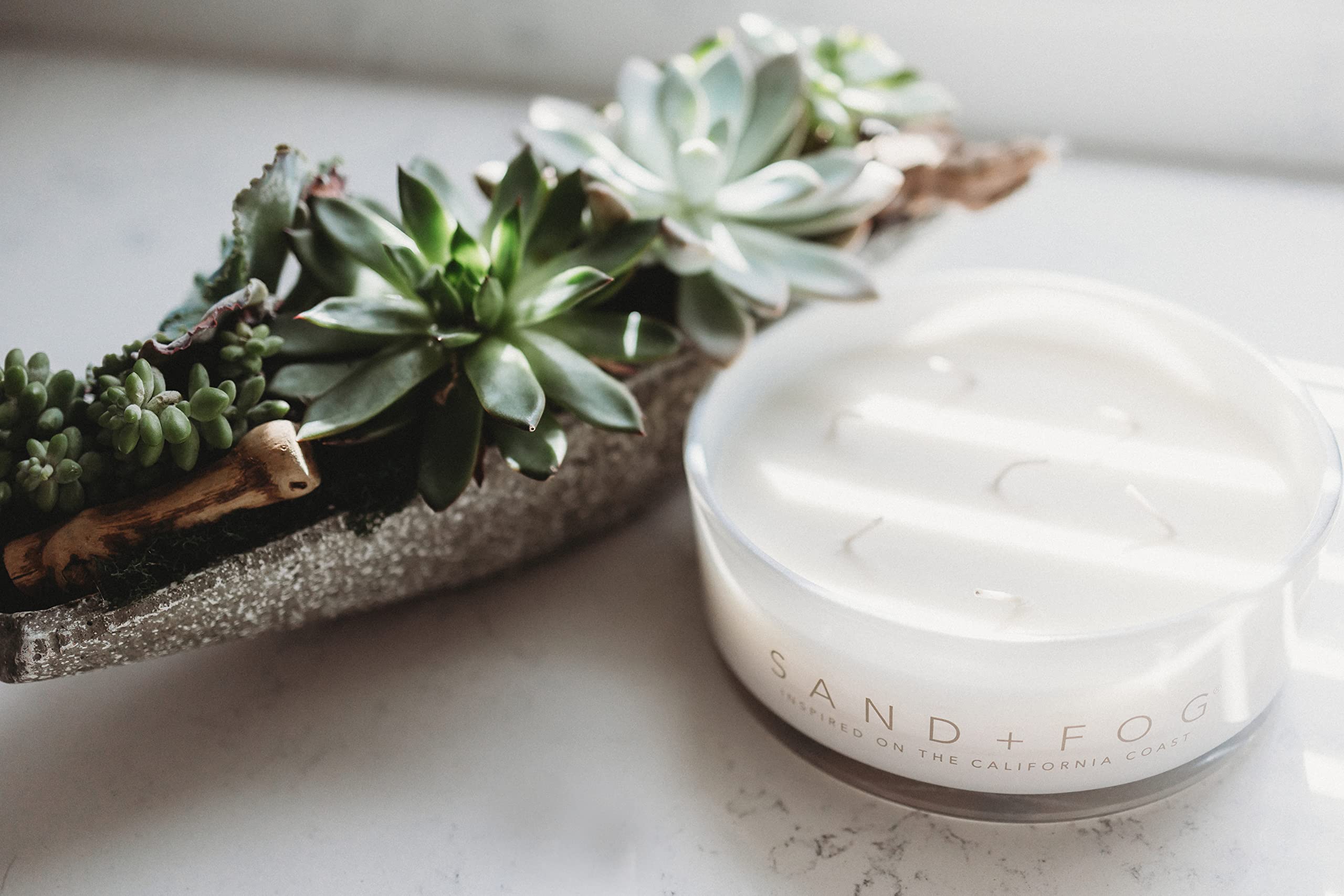 Sand + Fog Vanilla Sandalwood candle on living room decor setup.