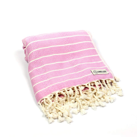 Sand Cloud Gocek Pink Turkish Beach Towel drying quickly after a swim.
