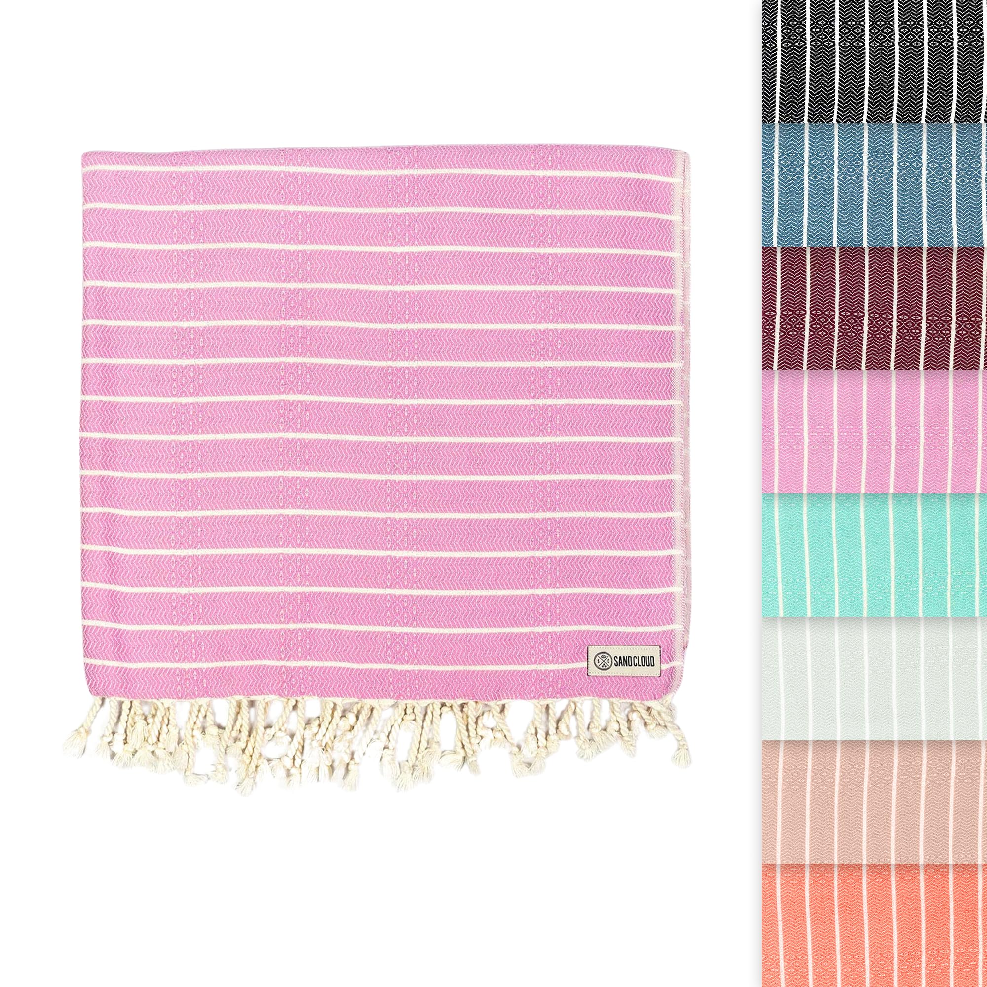 Sand Cloud Gocek Pink Turkish Beach Towel on sandy beach for comfortable sun days.