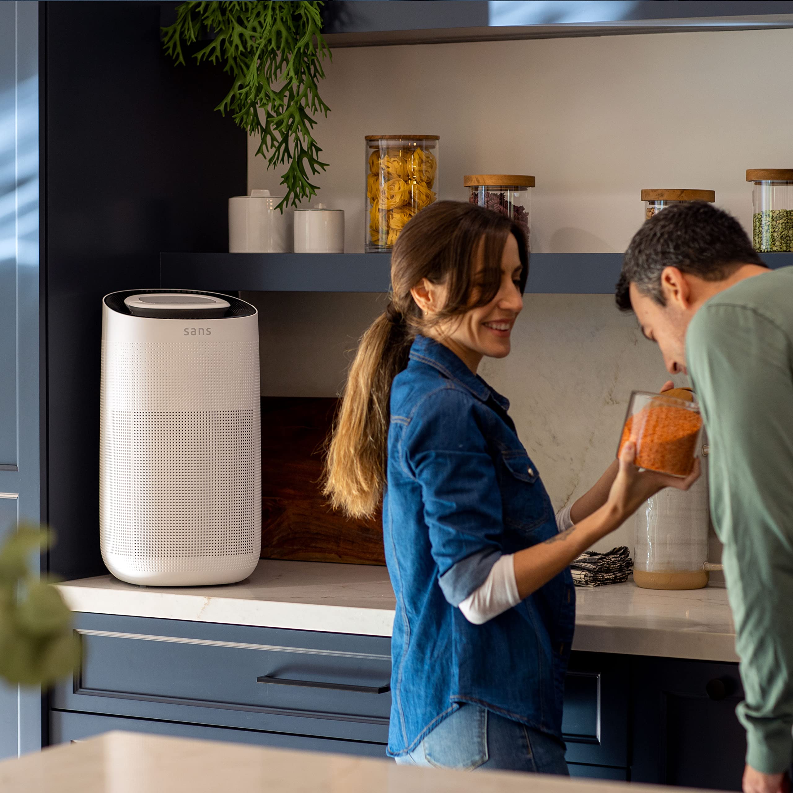 Sans HEPA 13 air purifier in white placed in a bright living room
