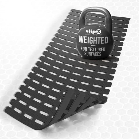 SlipX Solutions weighted bath mat on textured tub surface for secure placement.