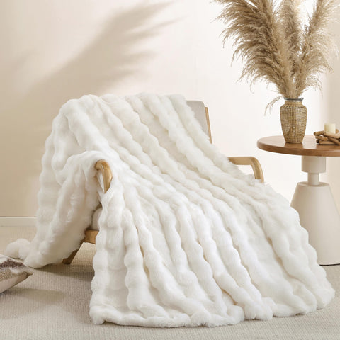 Smoofy cream white faux fur throw on couch, delivering luxurious warmth and a plush look.