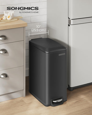 SONGMICS slim trash can positioned between counter and wall in a tight gap.