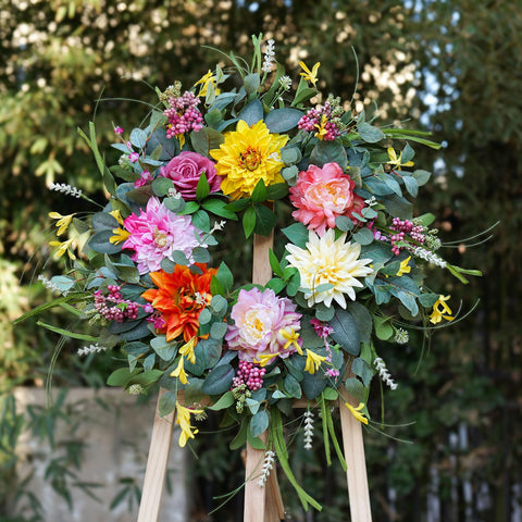 Soomeir wreath features a sturdy grapevine base with lush greenery.