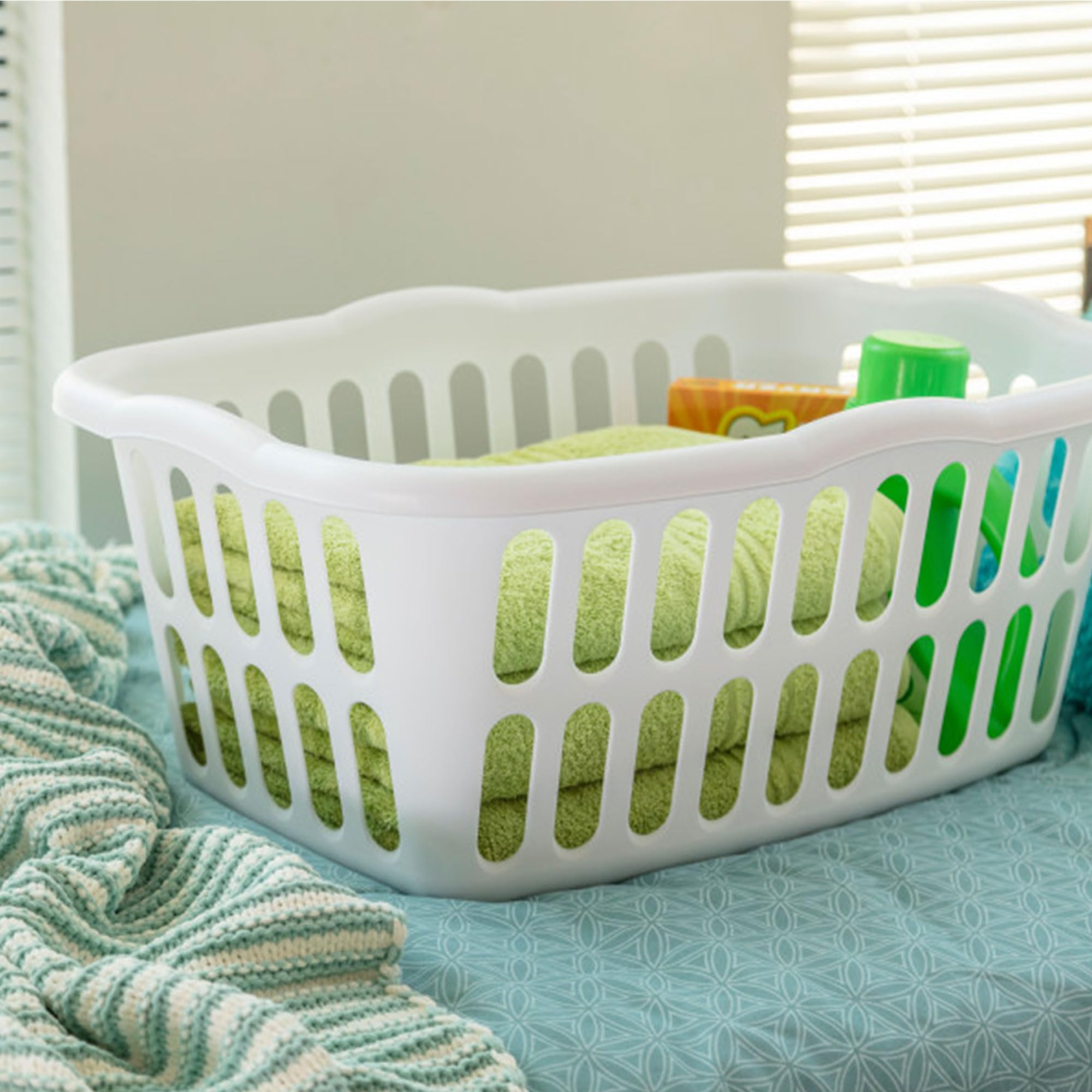 Sterilite white laundry basket with vented oval holes for air circulation.