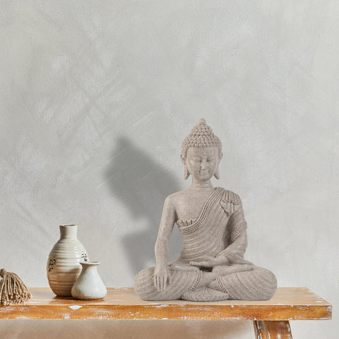 Suoedd Buddha statue on desk or shelf for zen-inspired decor.