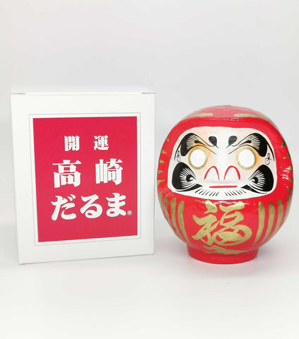 Paper mache texture close-up on Takasaki Daruma showing material quality