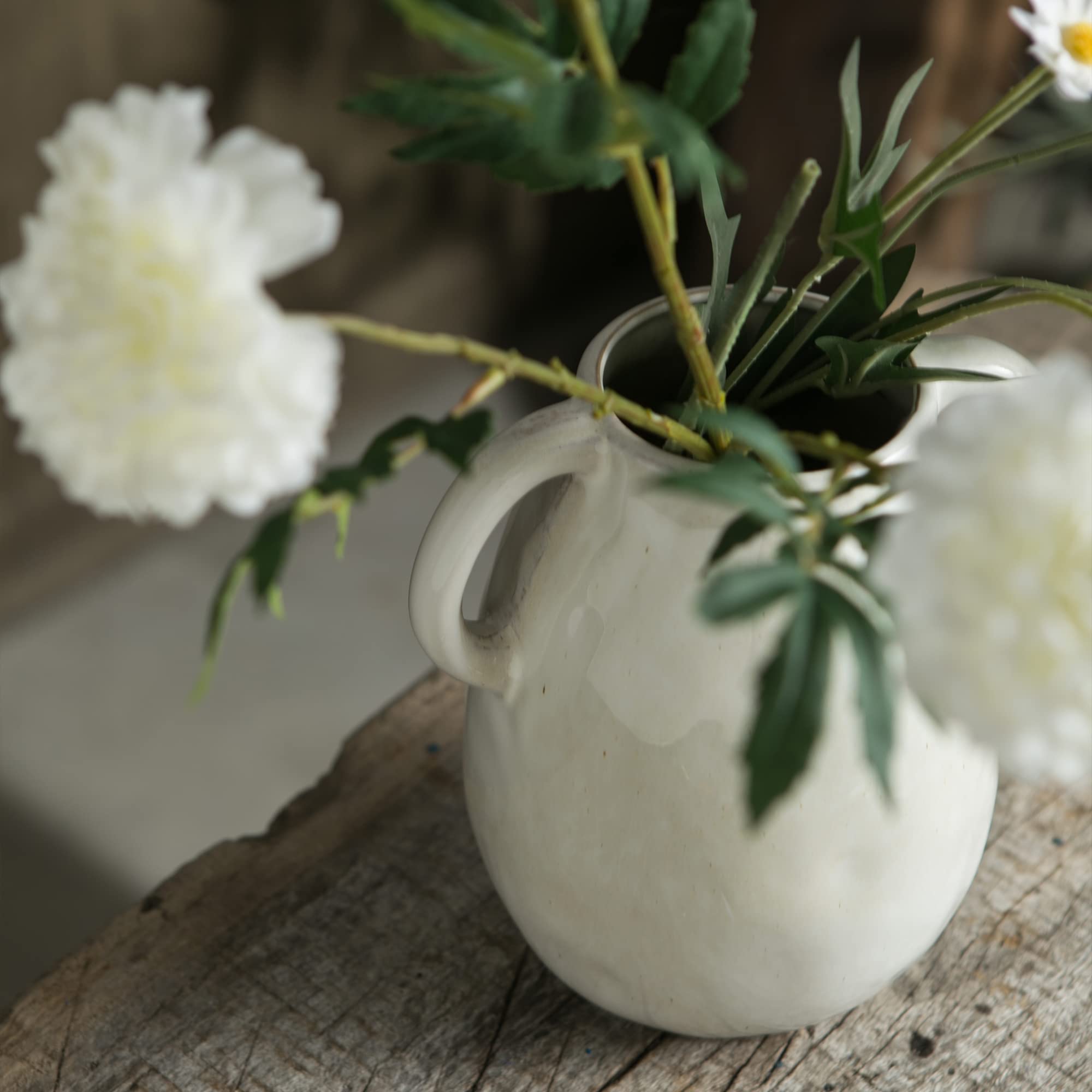 Tanvecle vase with faux flowers creating a chic centerpiece for dining.