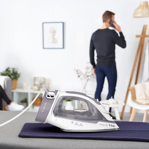 T-Fal Virtuo Steam Iron in use on shirts demonstrates quick wrinkle removal.