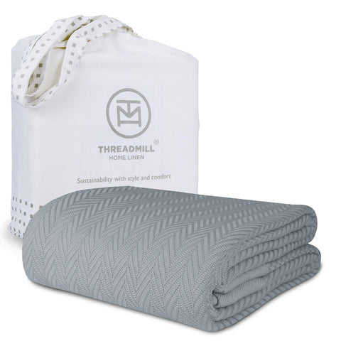 Threadmill luxury cotton blanket in Scottish Grey on a queen bed for all-season comfort.