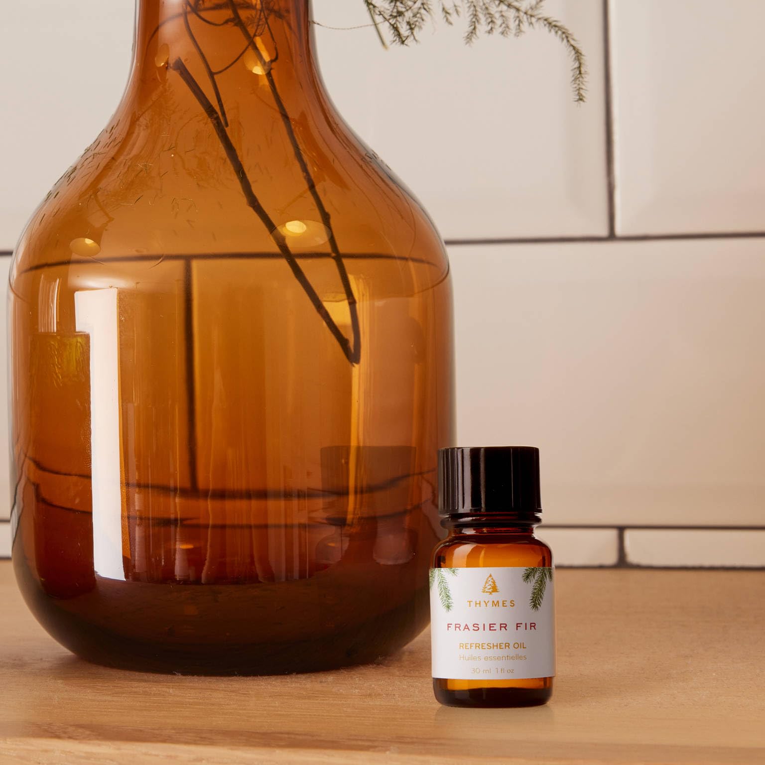 Thymes Frasier Fir Refresher Oil close-up showing needles and cedarwood hints.