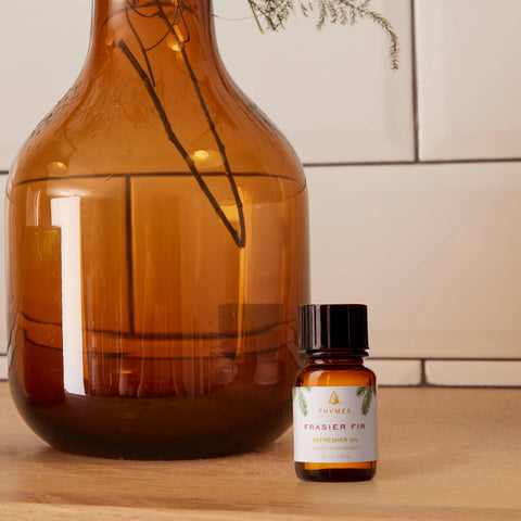 Thymes Frasier Fir Refresher Oil close-up showing needles and cedarwood hints.