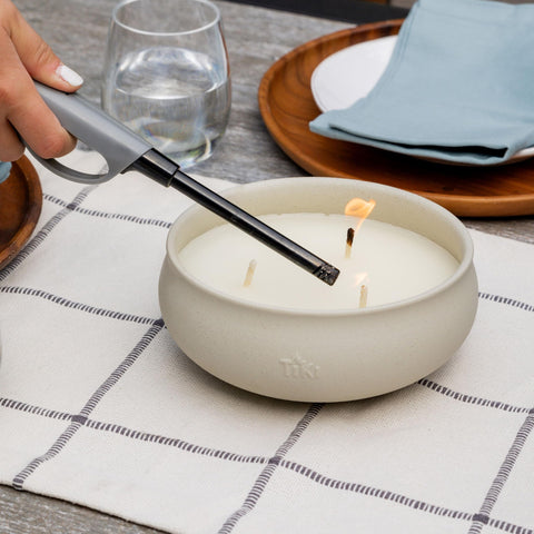 TIKI citronella candle on patio table helps create inviting outdoor ambience at dusk.