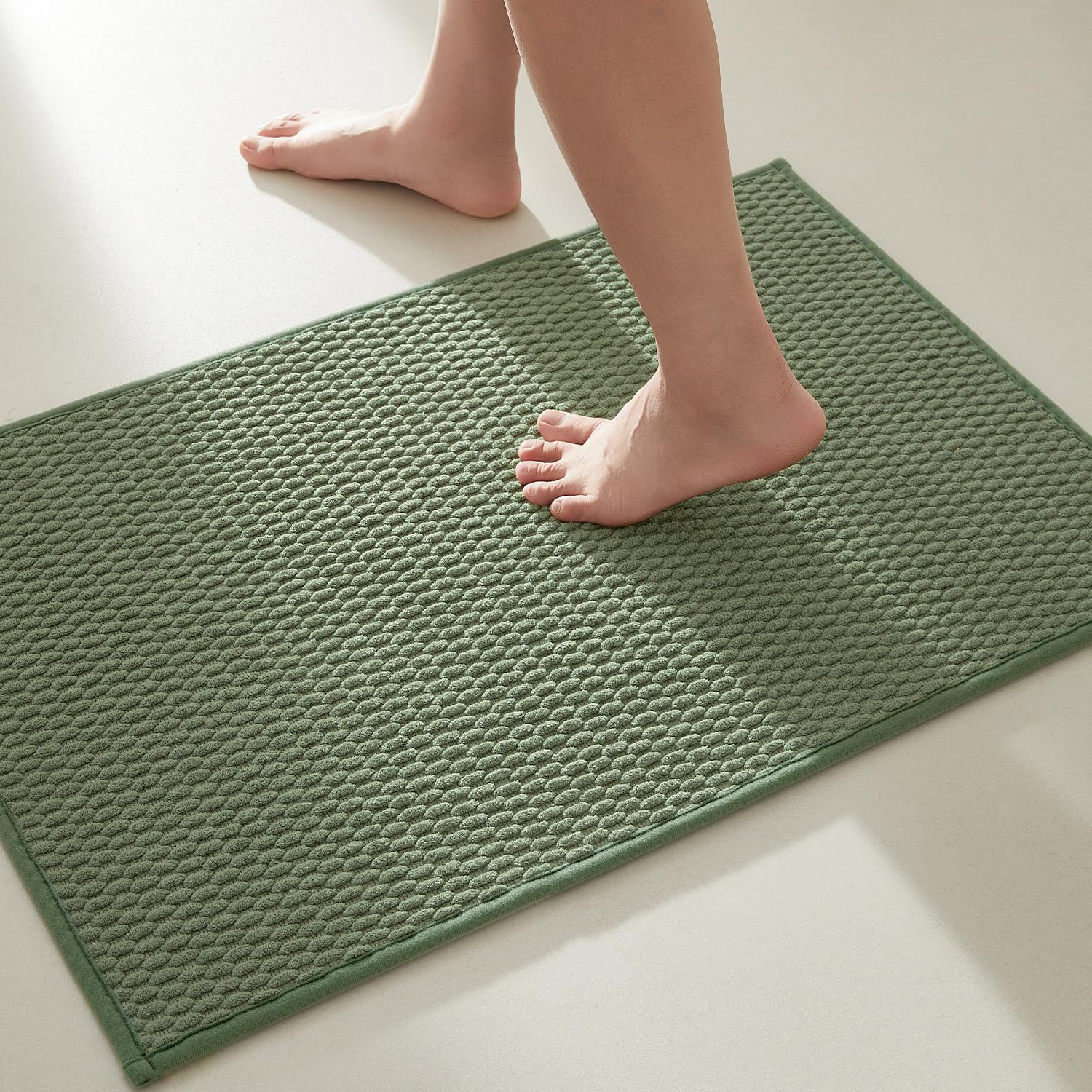 TYUU sage-green bath rug with non-slip backing keeps feet safe.