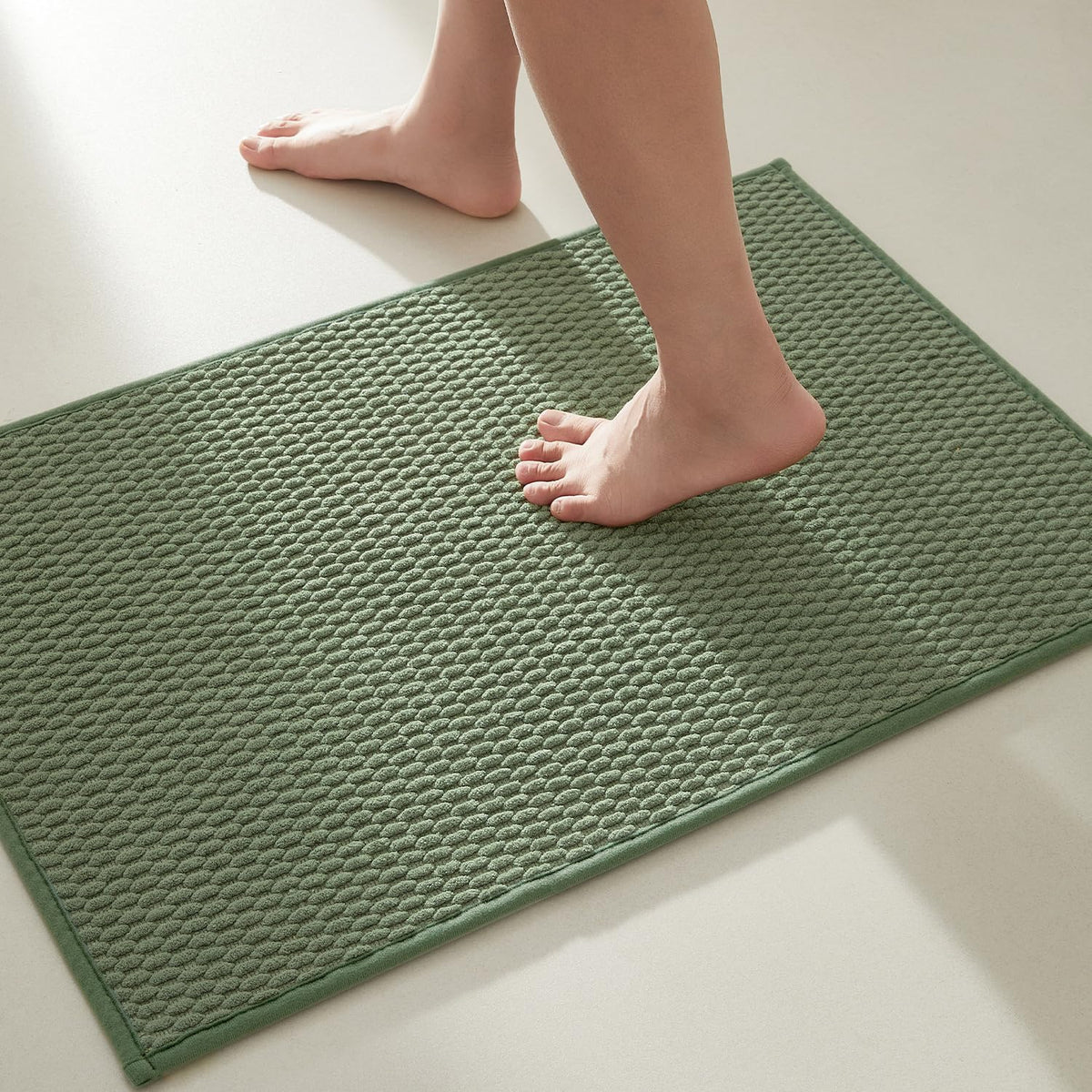 TYUU sage-green bath rug with non-slip backing keeps feet safe.