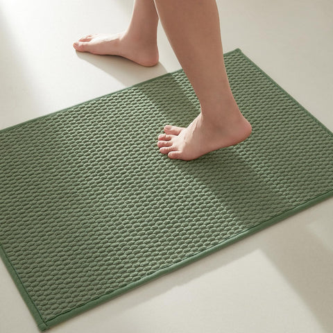 TYUU sage-green bath rug with non-slip backing keeps feet safe.