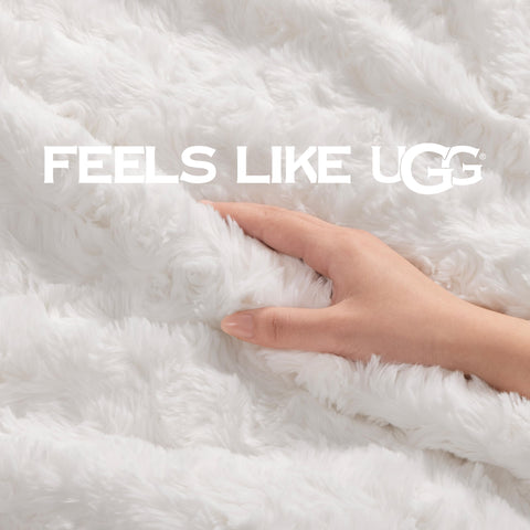 UGG Adalee white faux fur throw blanket adds soft warmth to bedroom decor.