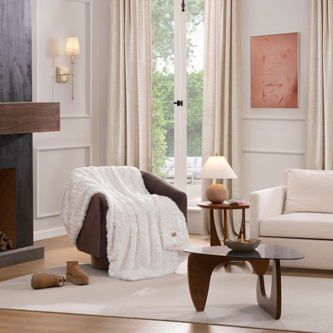 UGG Adalee white throw blanket on a chair creates a plush accent.