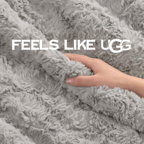 UGG Adalee grey 50x70 blanket draped over bed for neutral decor.
