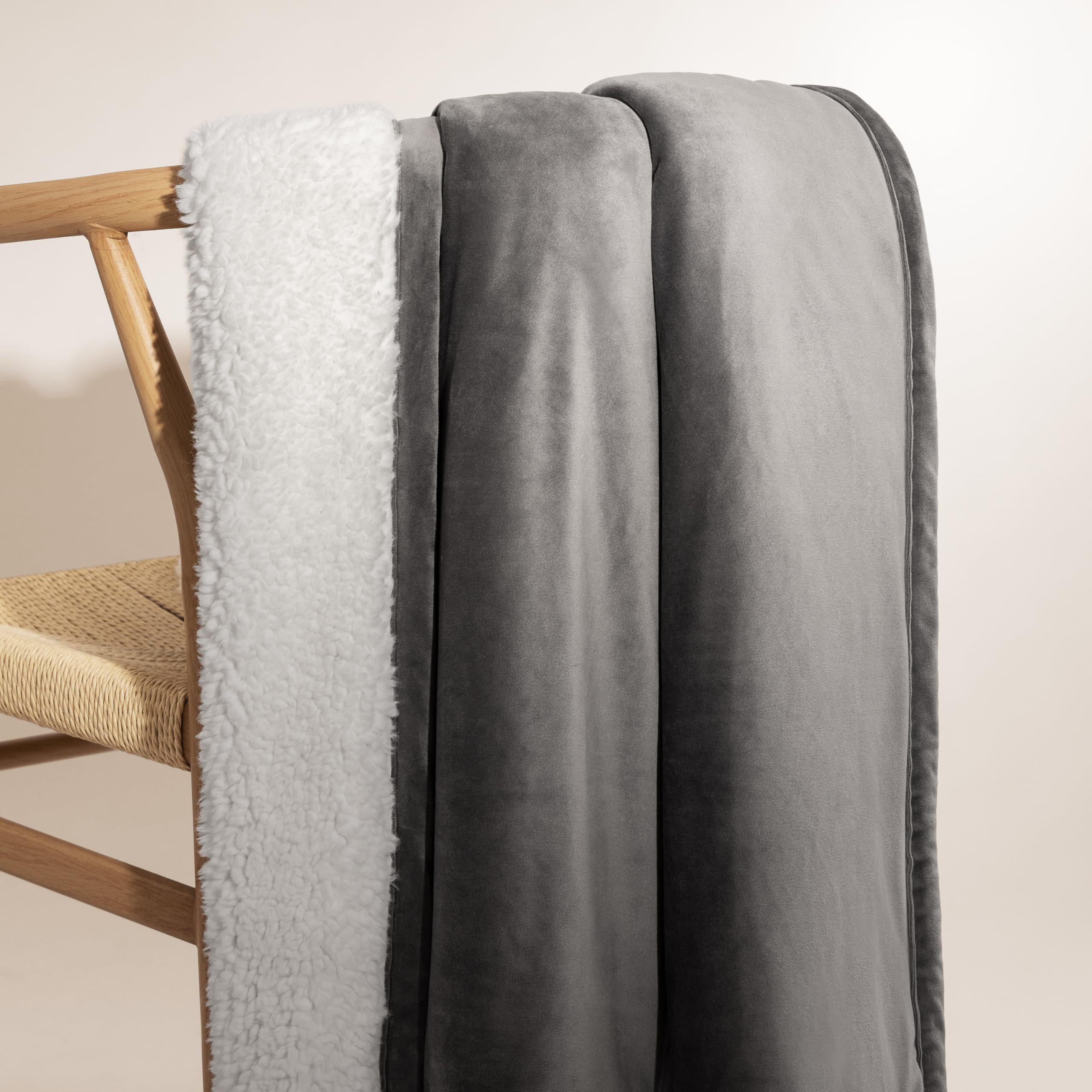 UGG Bliss Throw Blanket layered on a bed for warmth