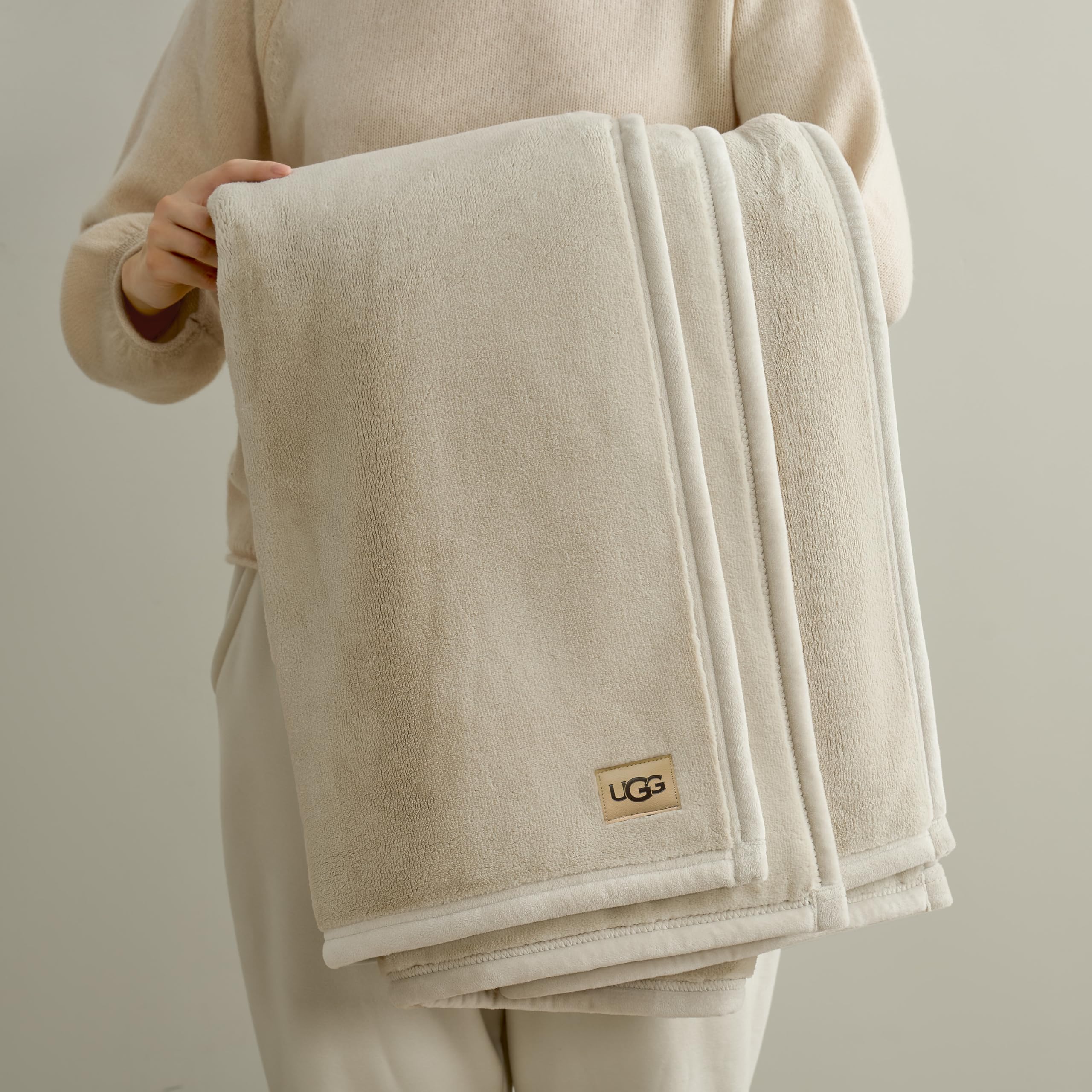 UGG Coco Plush Blanket on couch with pillows, enhances decor