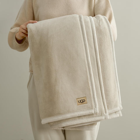 UGG Coco Plush Blanket on couch with pillows, enhances decor