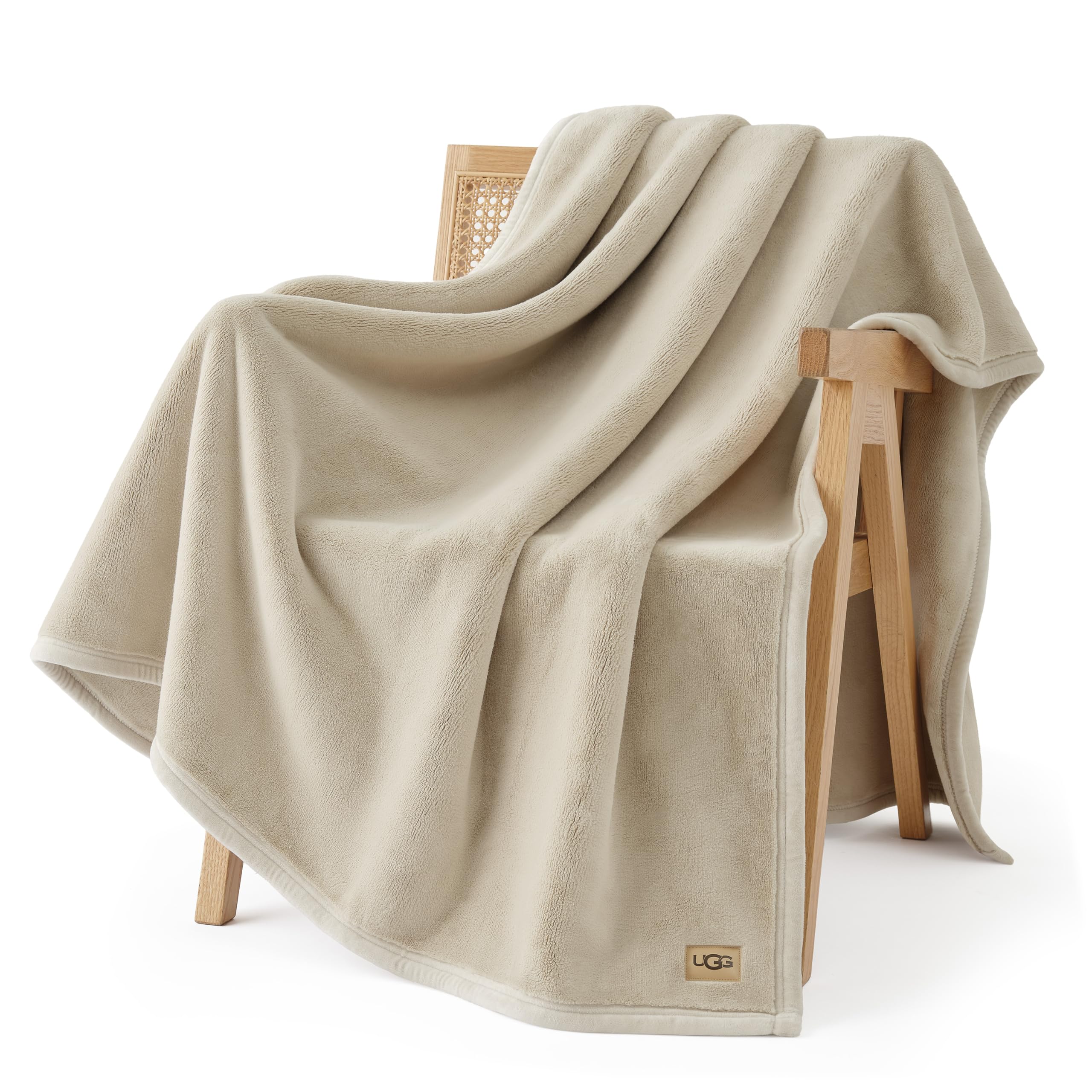 UGG Coco Plush Blanket folded on bed, adds soft warmth to nights