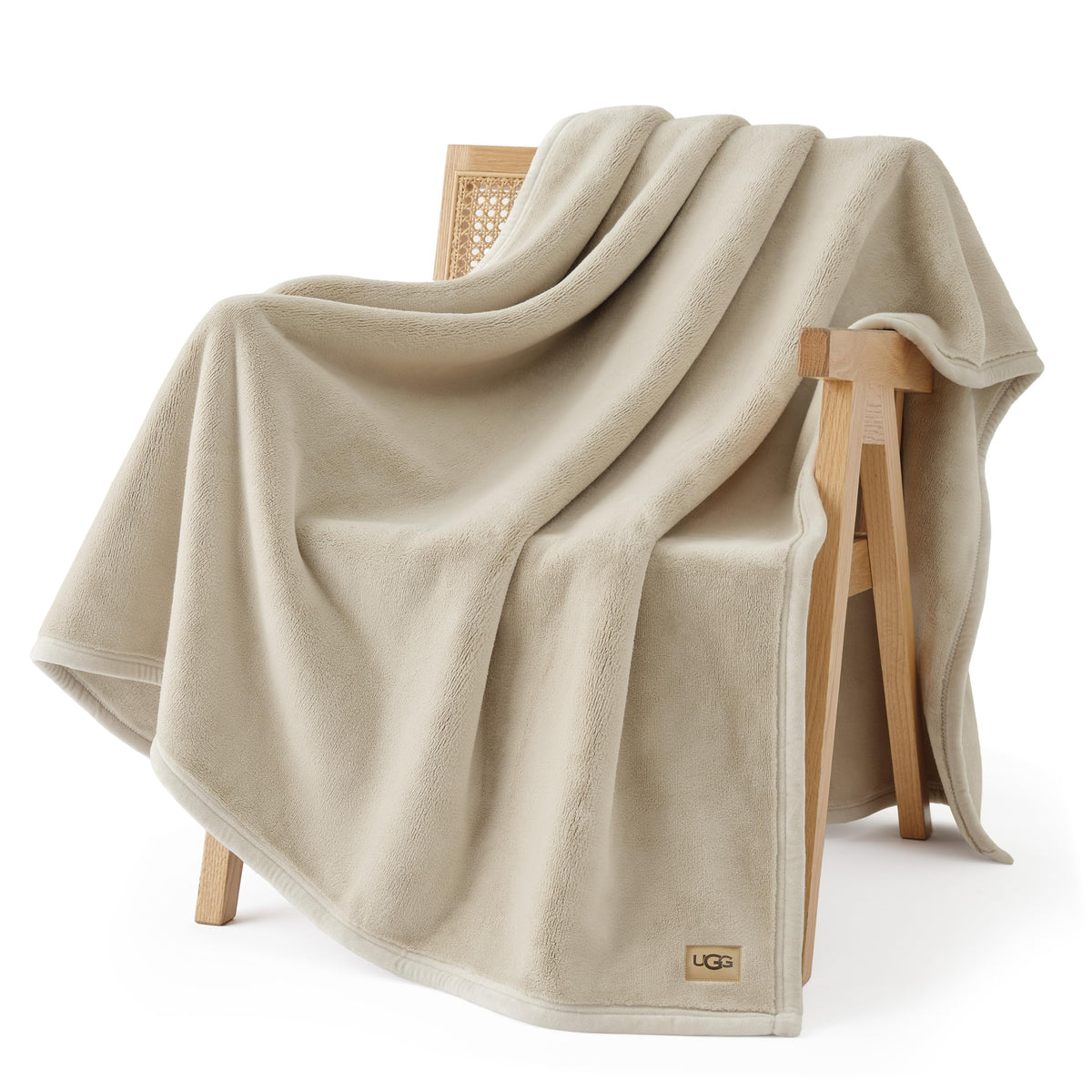 UGG Coco Plush Blanket folded on bed, adds soft warmth to nights