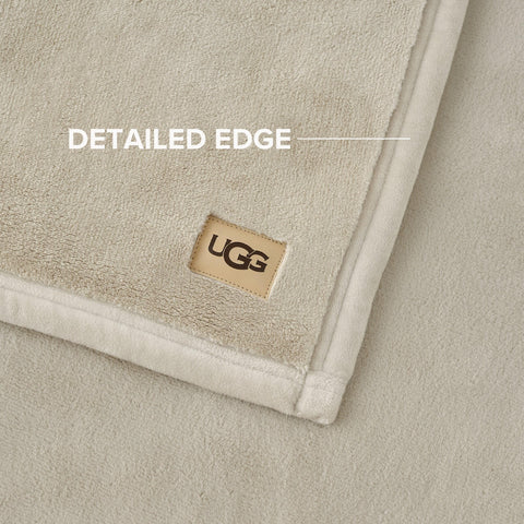 UGG Coco Plush Blanket draped over chair, ideal for reading