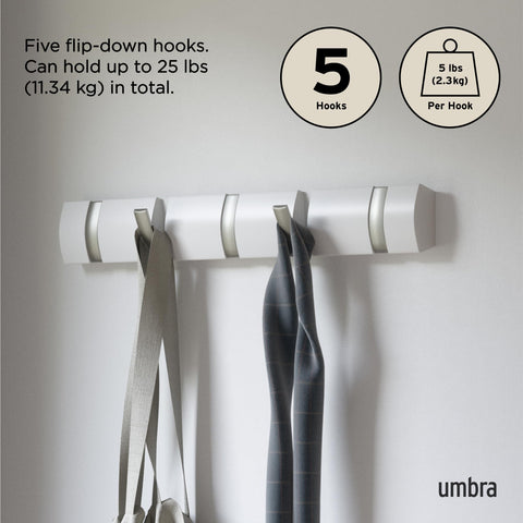 Umbra Flip coats and bags organized on a slim wall rail.