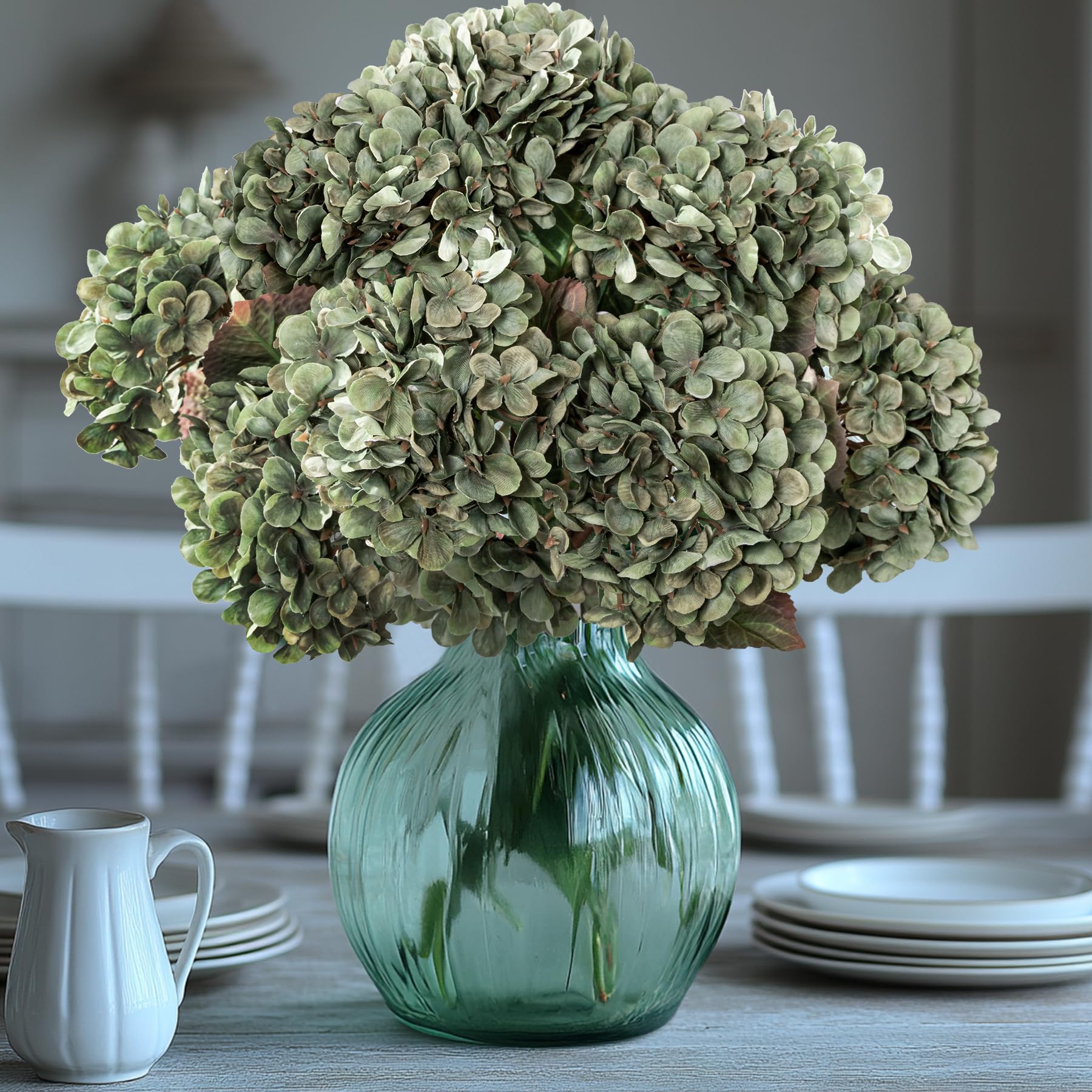 Uqueeten Hydrangea arrangement on a dining table centers a decorative scene.