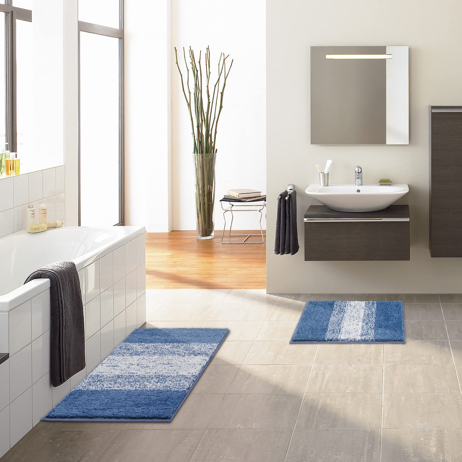 Vaukki blue striped rug complements towels and decor.