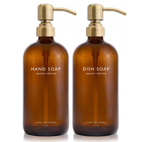 Vine Creations amber glass soap dispenser set with a brushed brass pump on the countertop.