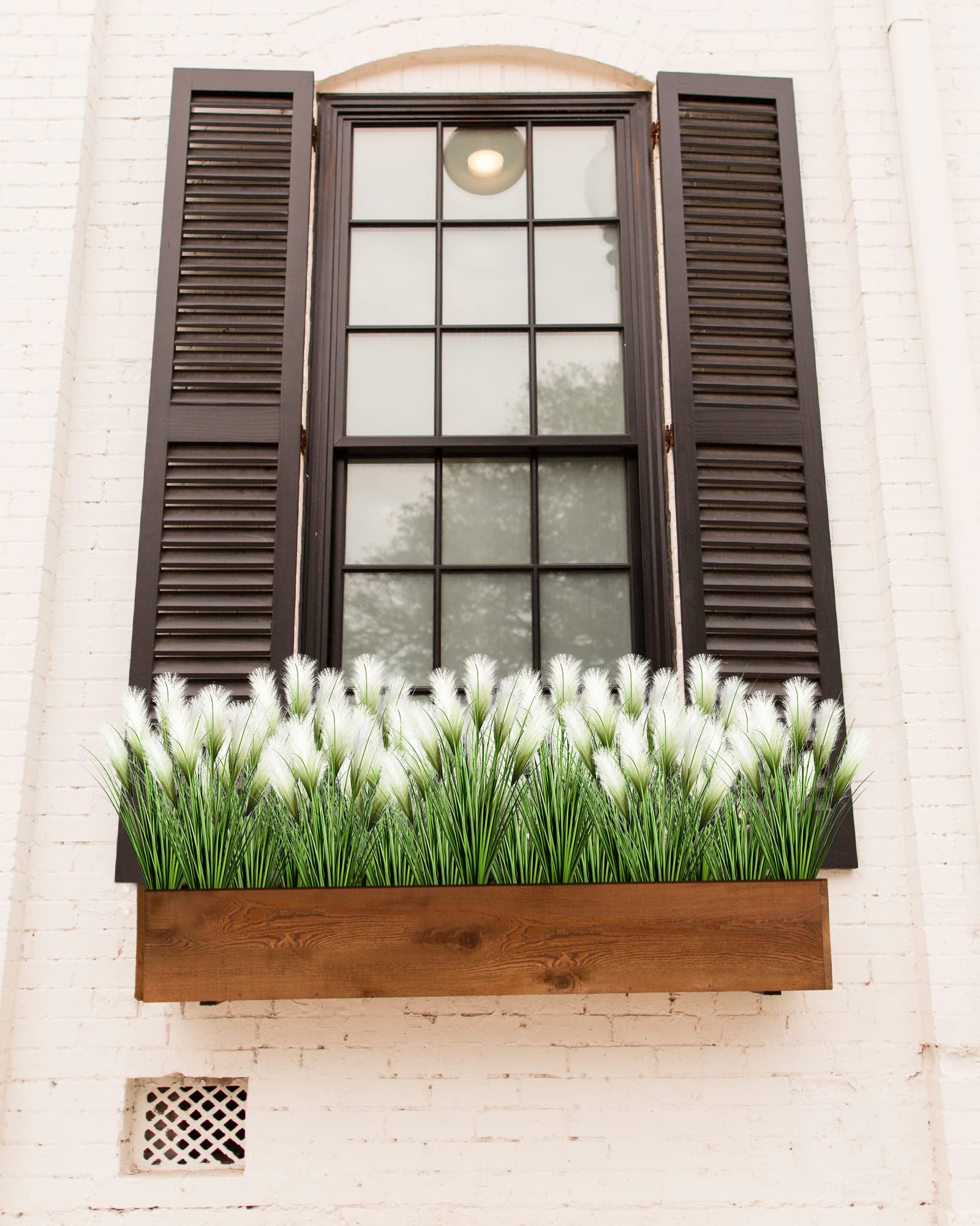 Vlorart realistic grass bunches create vibrant focal points in living rooms.