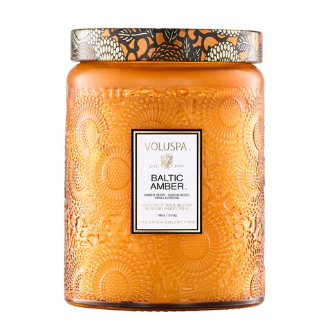 Voluspa Baltic Amber Candle Jar glowing warmly, ideal for cozy living spaces.