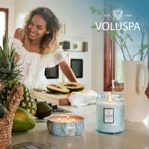 Voluspa candle on coffee table ready to refresh home ambiance.