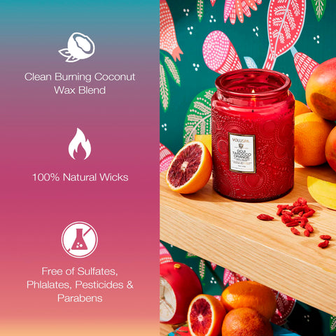 Voluspa Goji Tarocco Orange candle emits a cozy amber glow, enhancing living room ambiance.