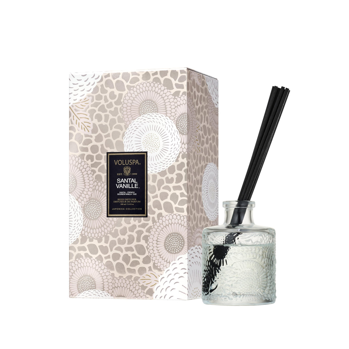 Voluspa Santal Vanille diffuser in glass vessel enhances living room ambiance.