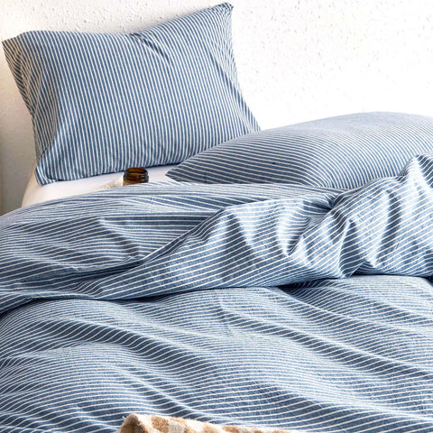 Wake In Cloud striped cotton duvet cover in denim blue with corner ties and zipper.