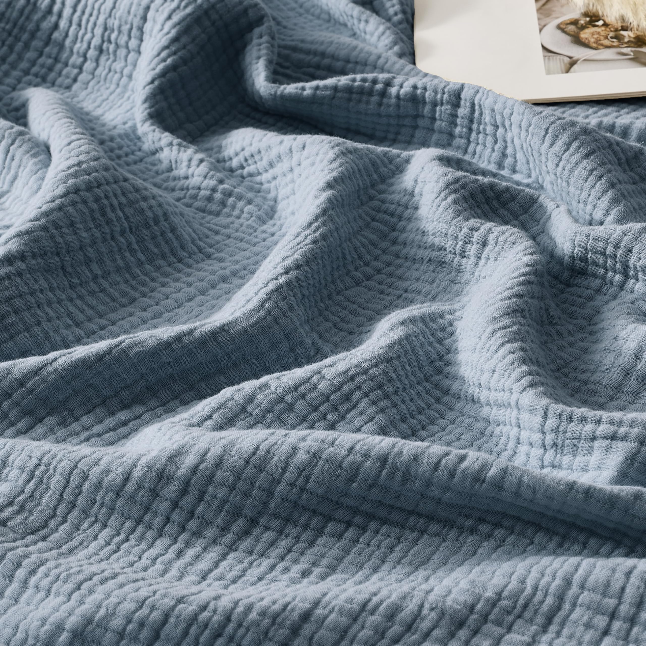 WDCOZY muslin blanket in dusty blue with soft texture for cozy evenings.