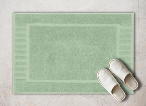 White Classic bath mat by sink in green for convenient floor comfort.