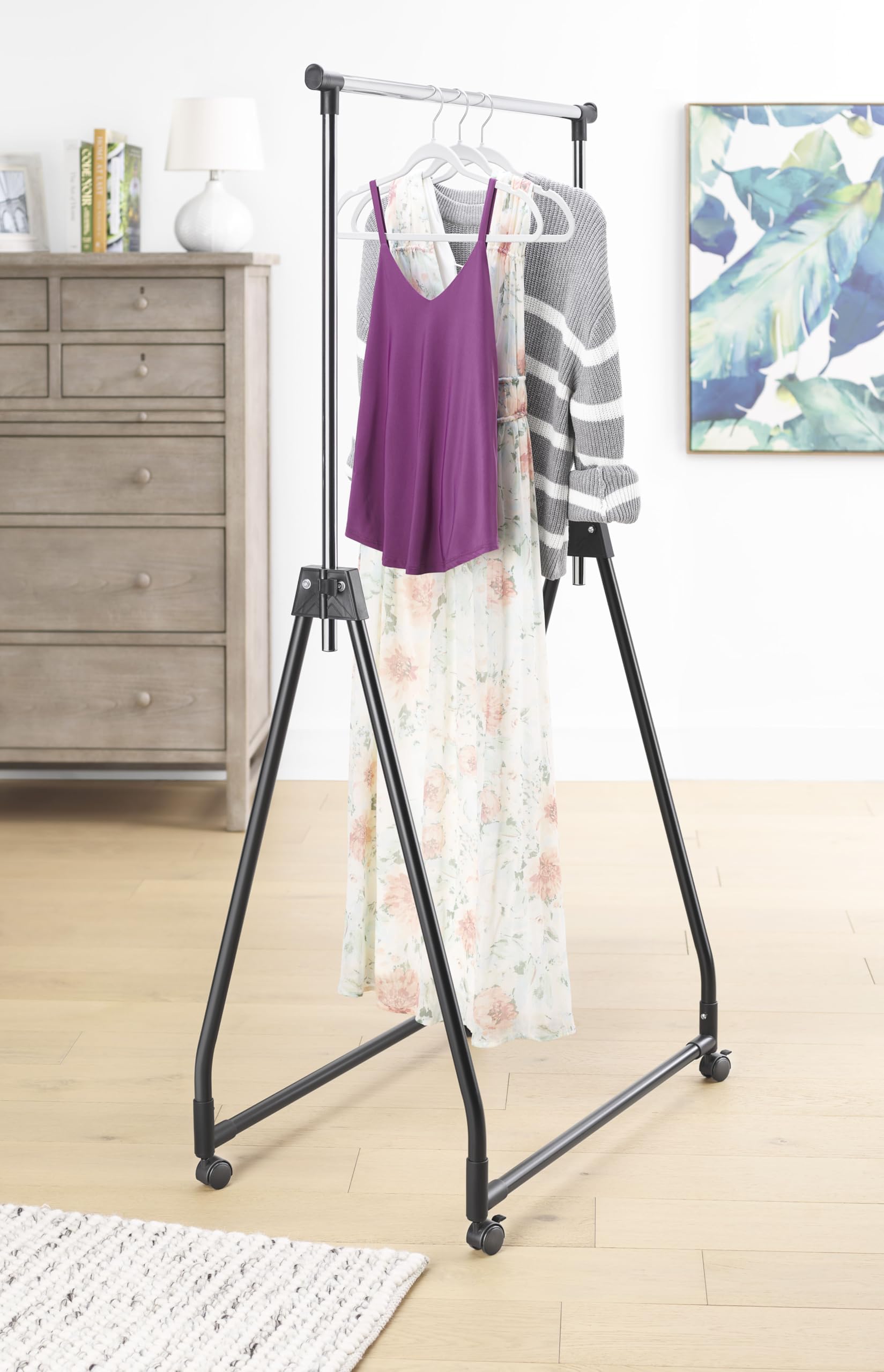 Whitmor folding garment rack with rolling hanger offering portable wardrobe space.