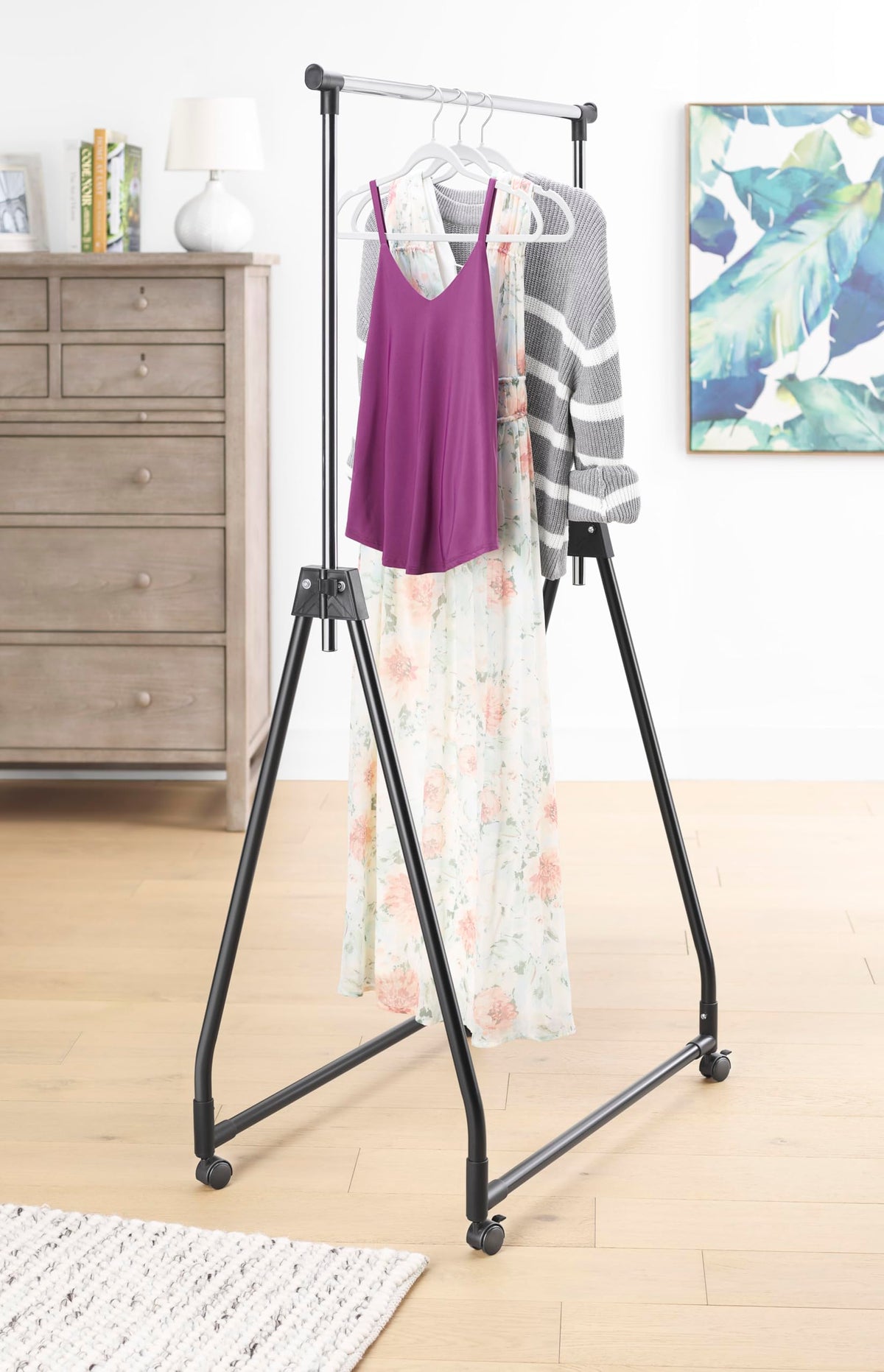 Whitmor folding garment rack with rolling hanger offering portable wardrobe space.