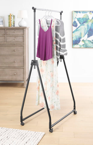 Whitmor folding garment rack with rolling hanger offering portable wardrobe space.