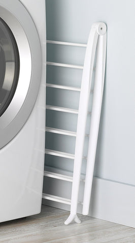 Whitmor Spacemaker drying rack stored flat beside a washing machine.