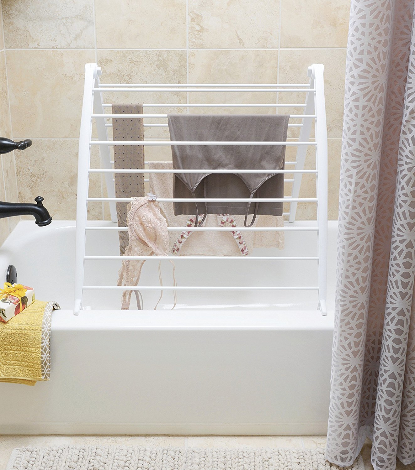 Whitmor Spacemaker drying rack leaned against a wall in a compact laundry area.
