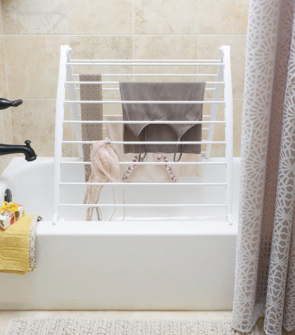 Whitmor Spacemaker drying rack leaned against a wall in a compact laundry area.
